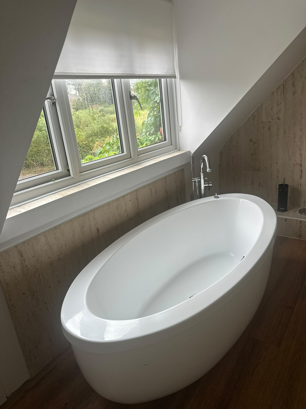 Deep-cleaned freestanding bath beside a spotless window